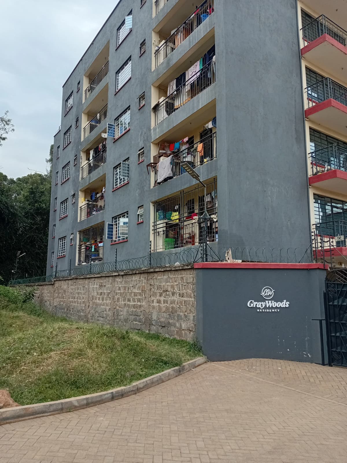 Multi-story residential building facade with balconies and entrance gate