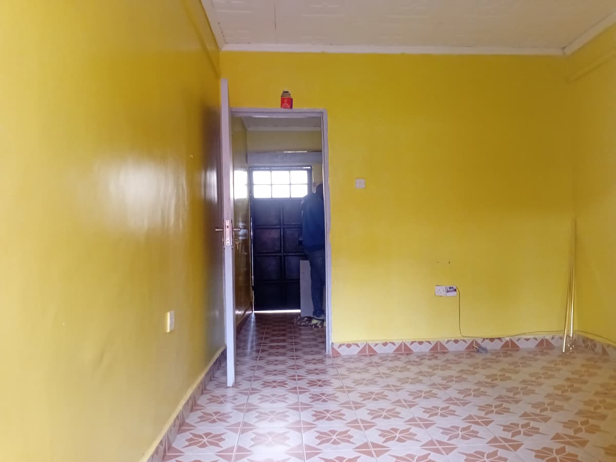 Bright yellow corridor with patterned tile flooring and entrance door