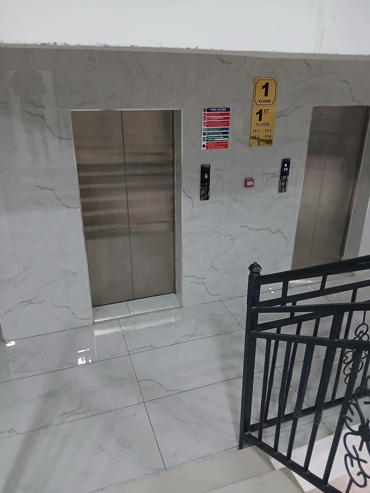 Modern lift lobby with dual elevators and marble flooring