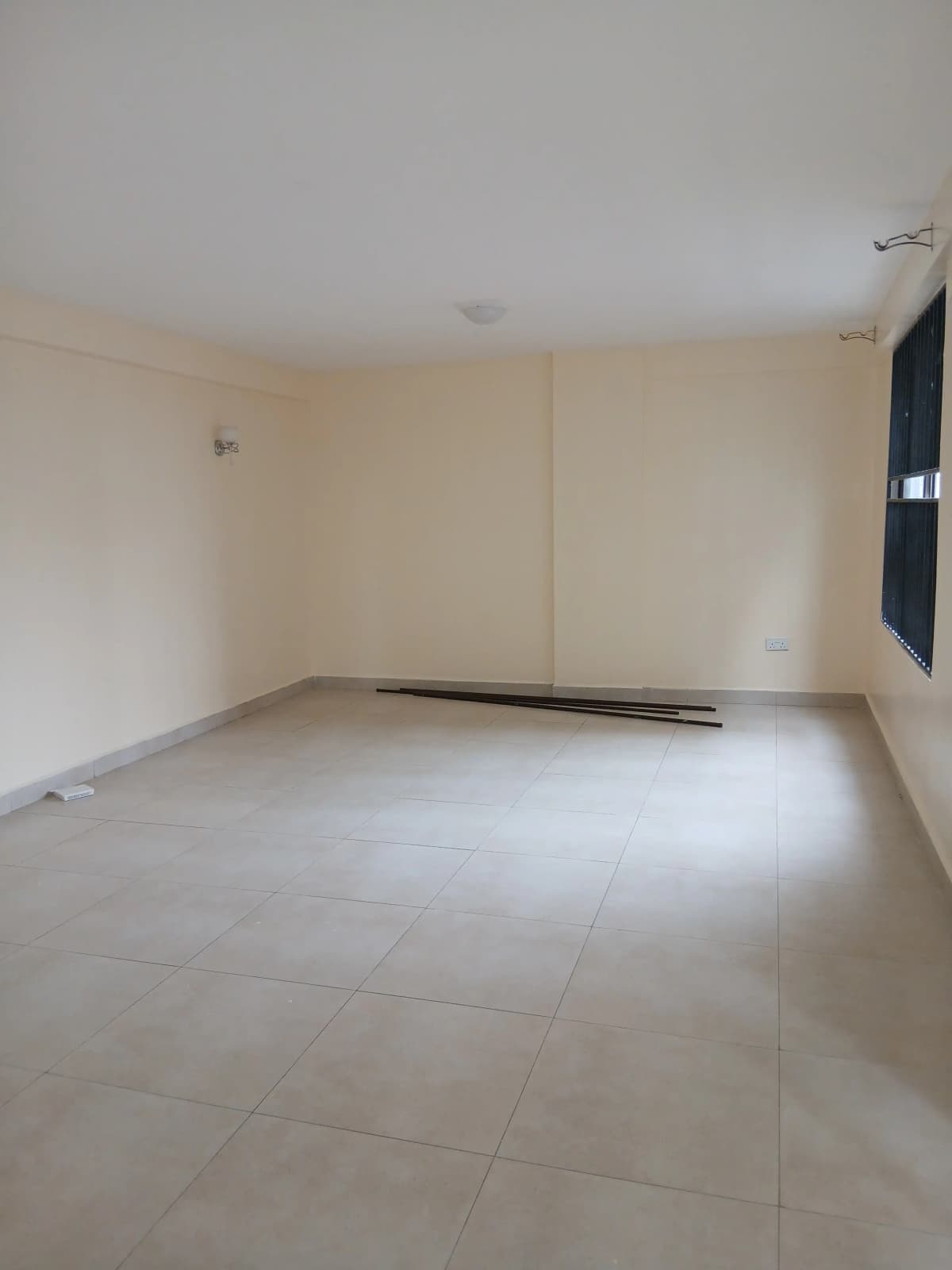 Empty living room with tiled flooring and neutral walls