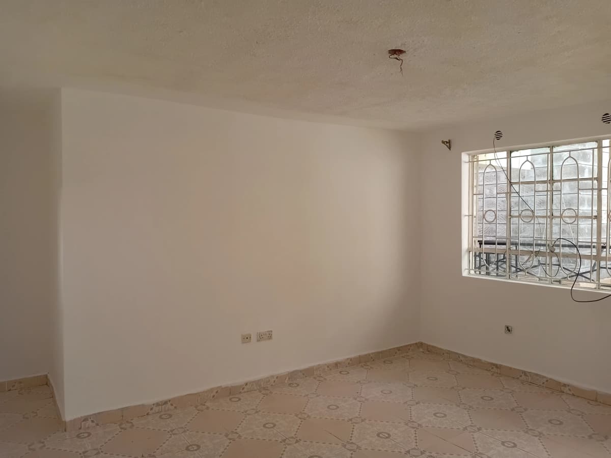 Empty bedroom with patterned floor and barred window