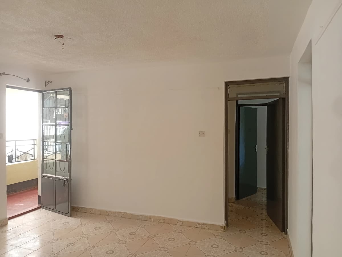 Empty living room with balcony access and tiled flooring