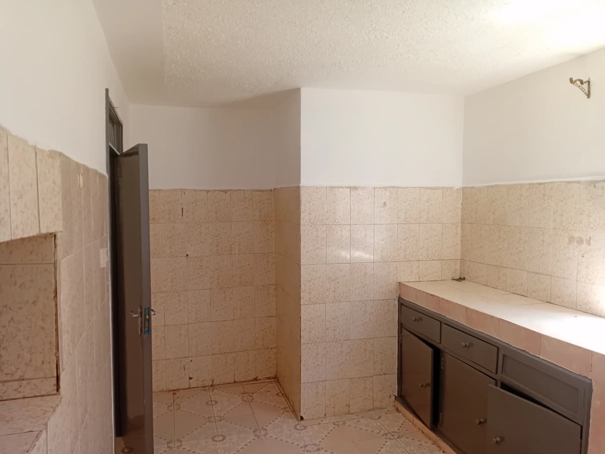 Empty bathroom with beige tiles and dark vanity cabinet