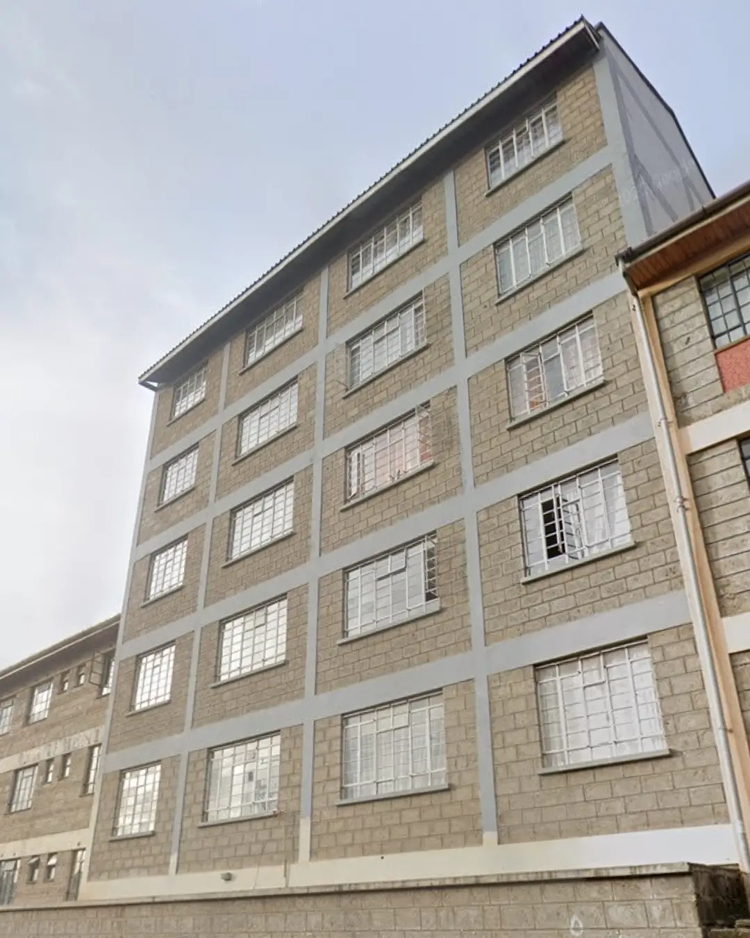Six-story residential building with stone facade and regular window grid