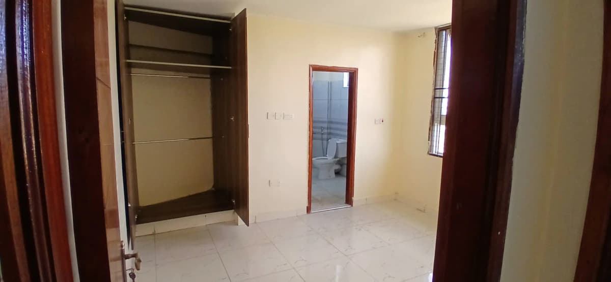 Unfurnished bedroom with built-in wardrobe and window