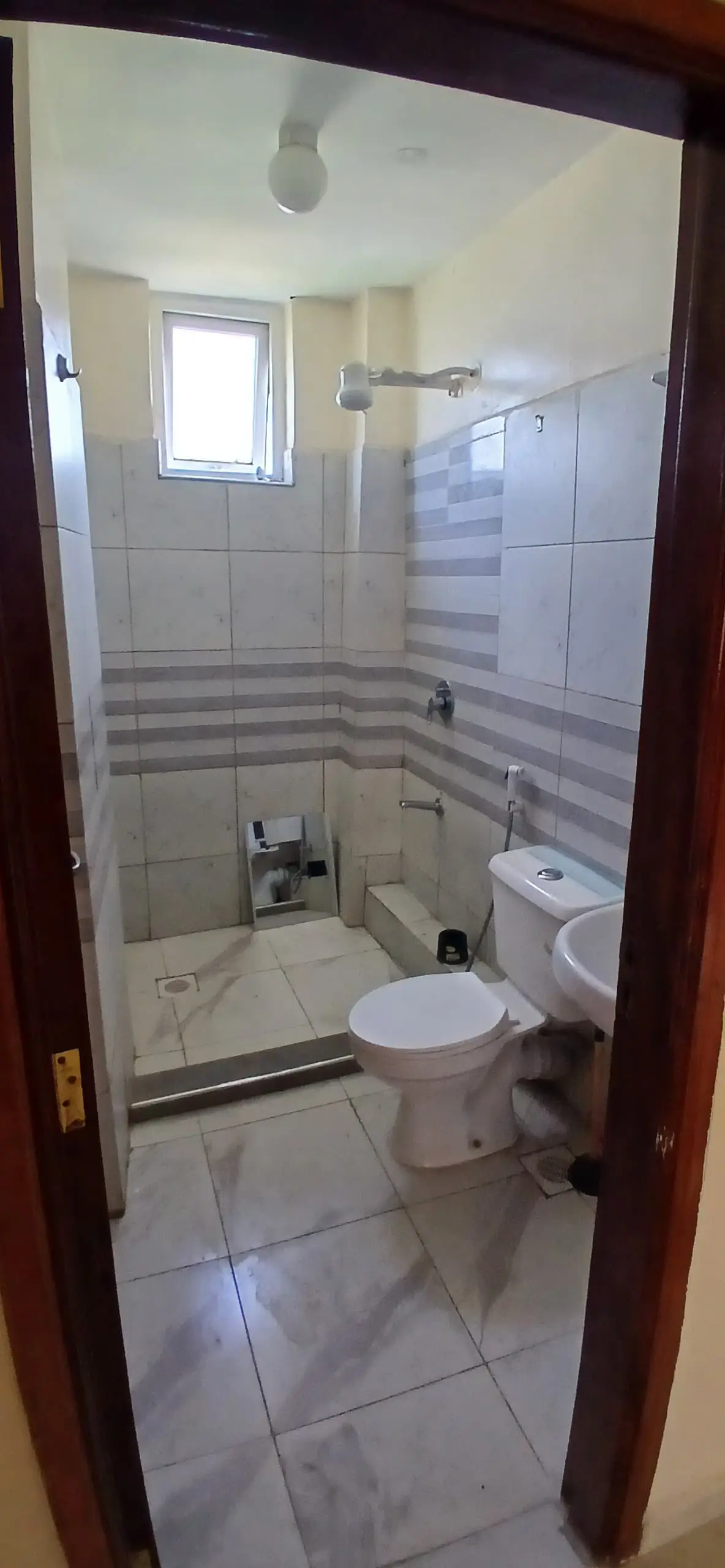Modern bathroom with shower enclosure, toilet, and window