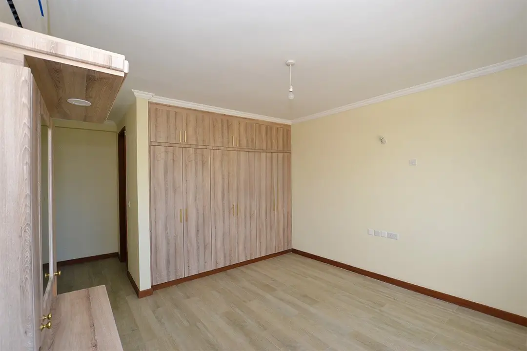 Spacious bedroom with built-in wooden wardrobe and en-suite access