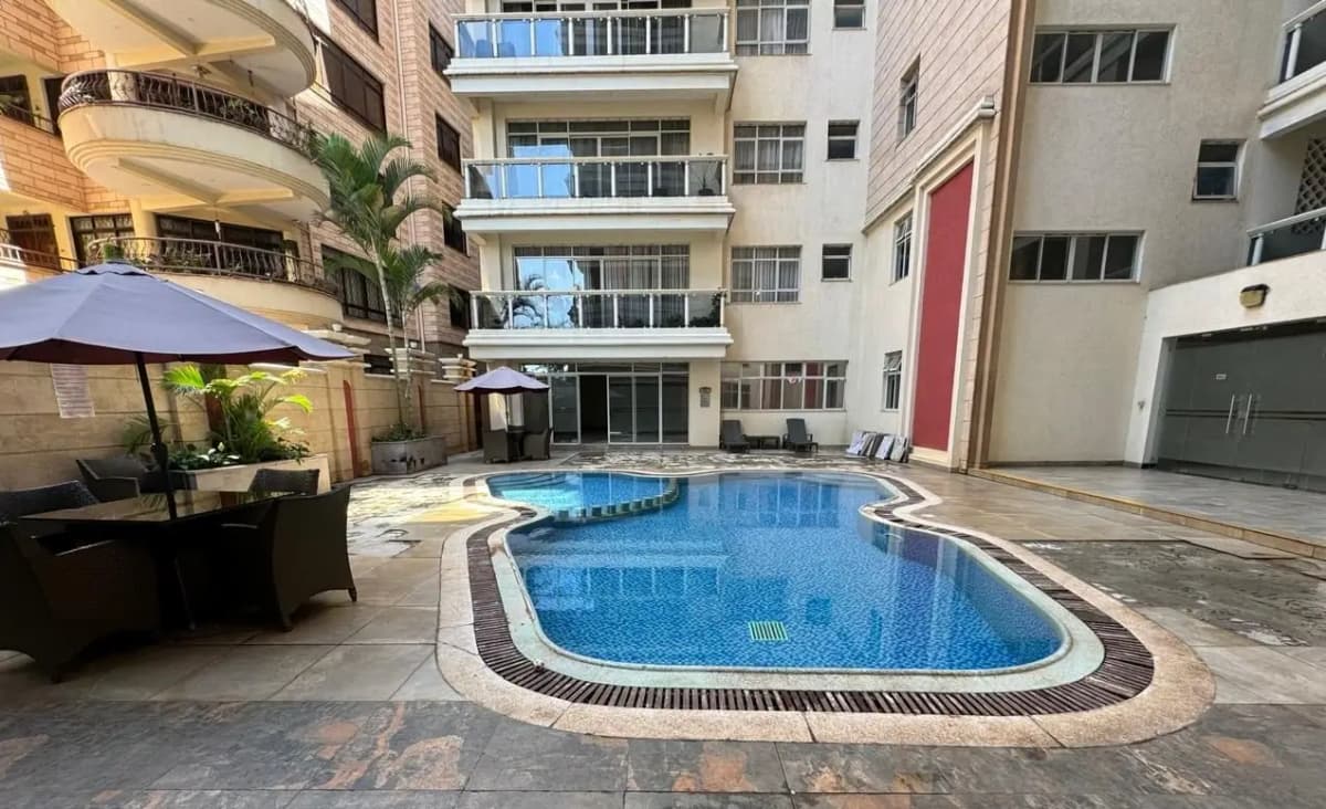 Resort-style swimming pool with lounging area and shade