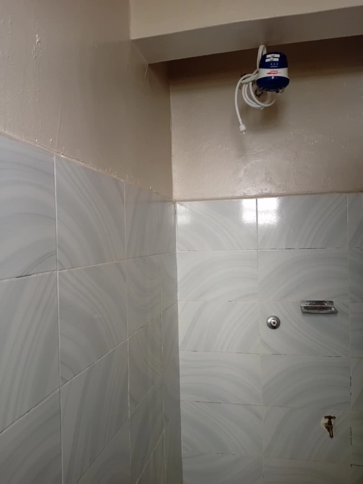 Tiled bathroom shower area with water meter installation