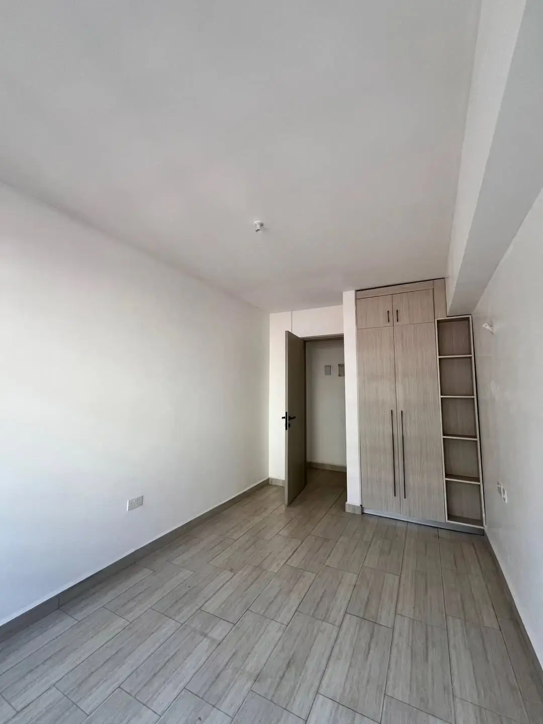 Bright bedroom with wooden flooring and built-in wardrobes