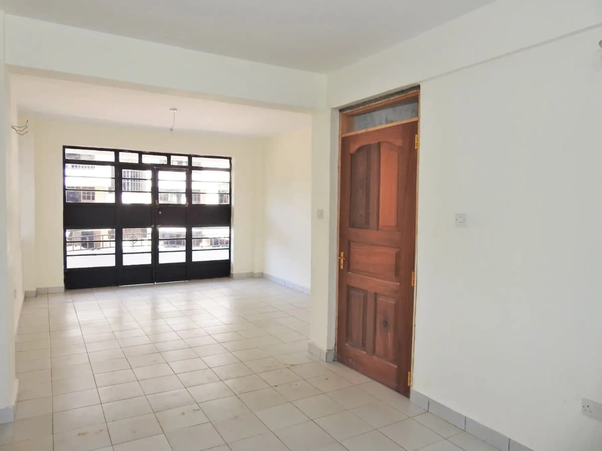 Spacious empty living room with tiled flooring and large windows