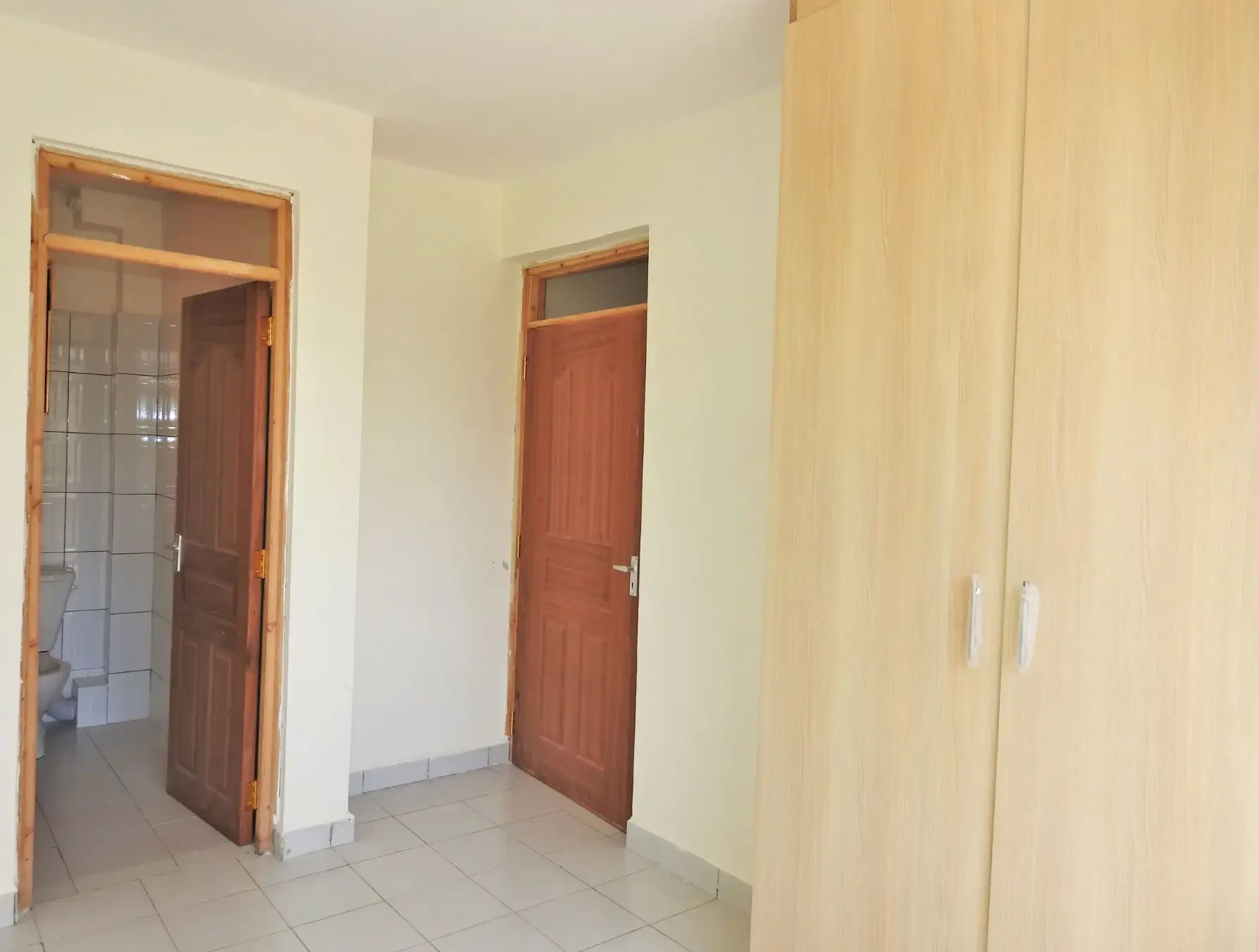 Unfurnished bedroom with built-in wardrobe and adjacent bathroom access