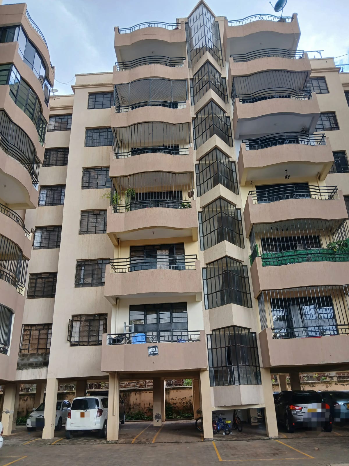 Multi-story residential building with balconies and ground-floor shops