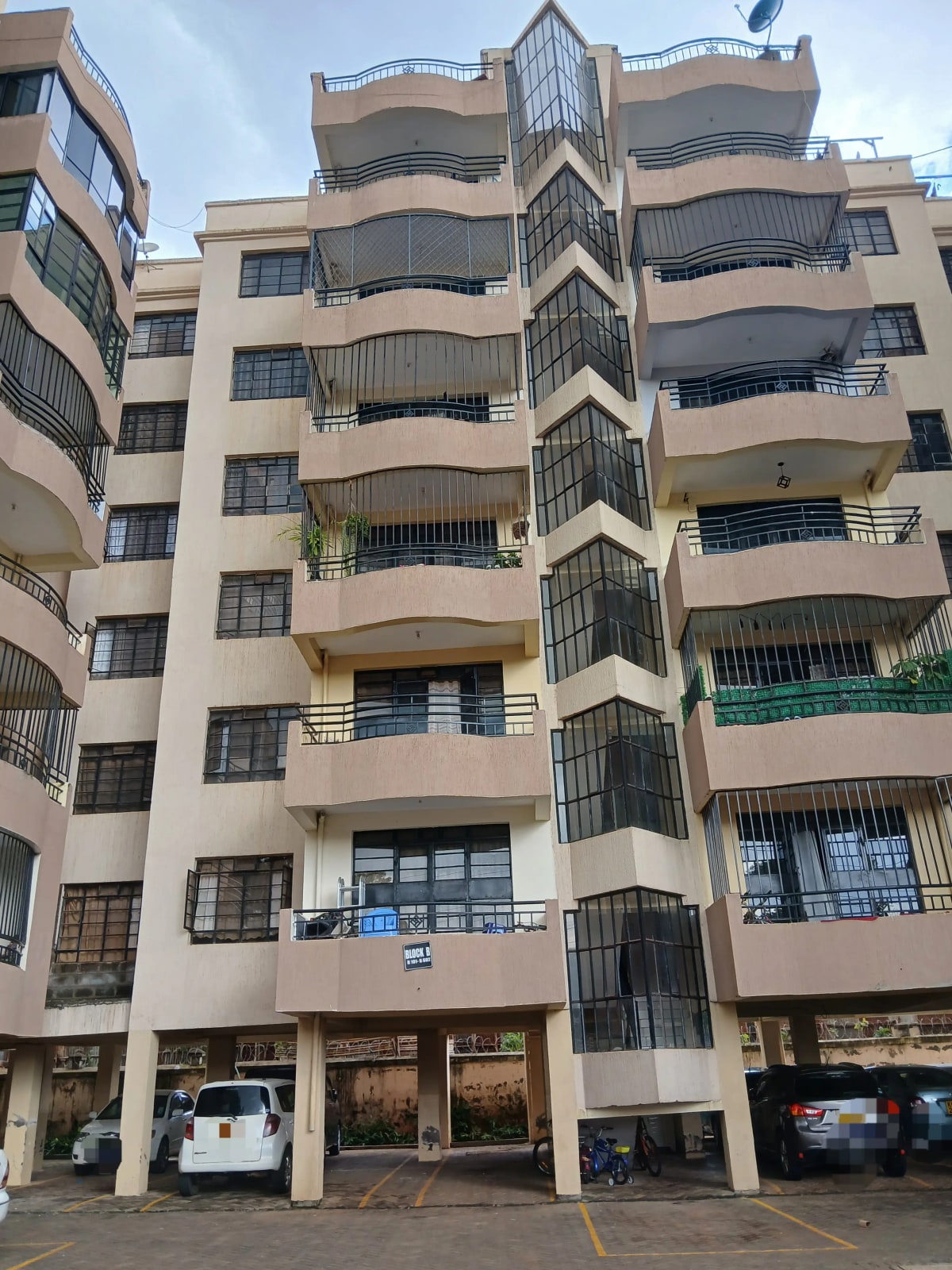 Multi-story residential building with balconies and ground-floor shops