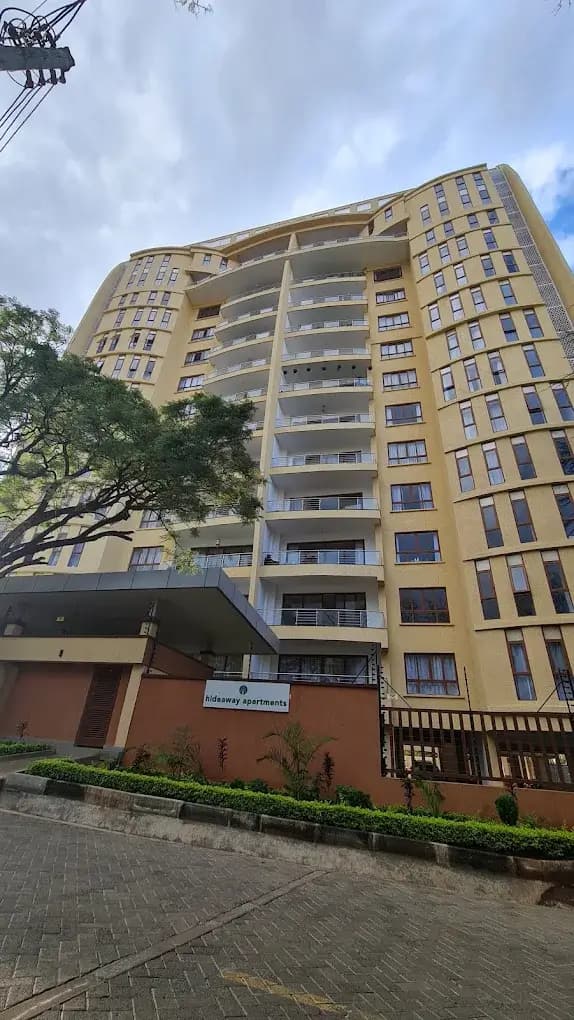 Multi-story residential building facade with yellow and cream exterior