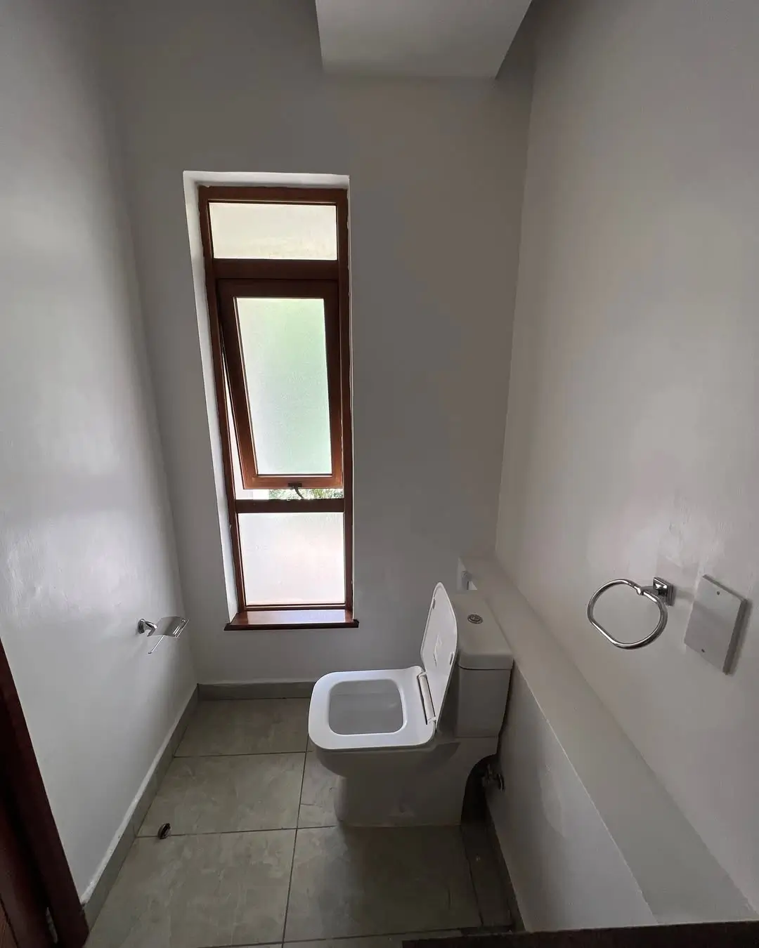 Compact bathroom with toilet and vertical window