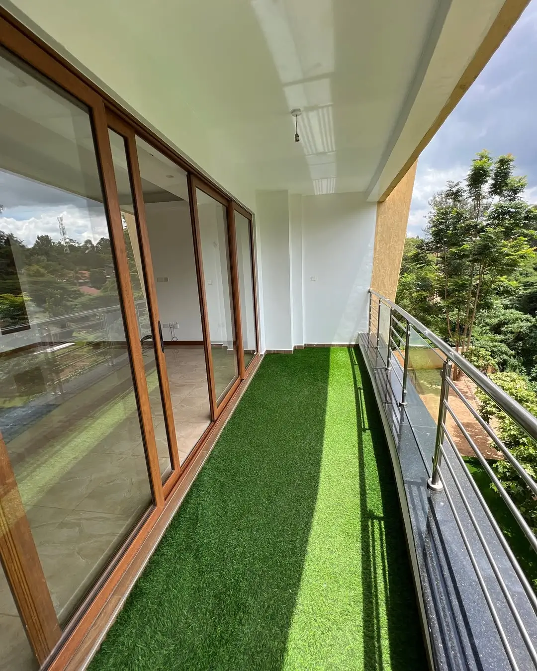 Narrow balcony with artificial turf and metal railings