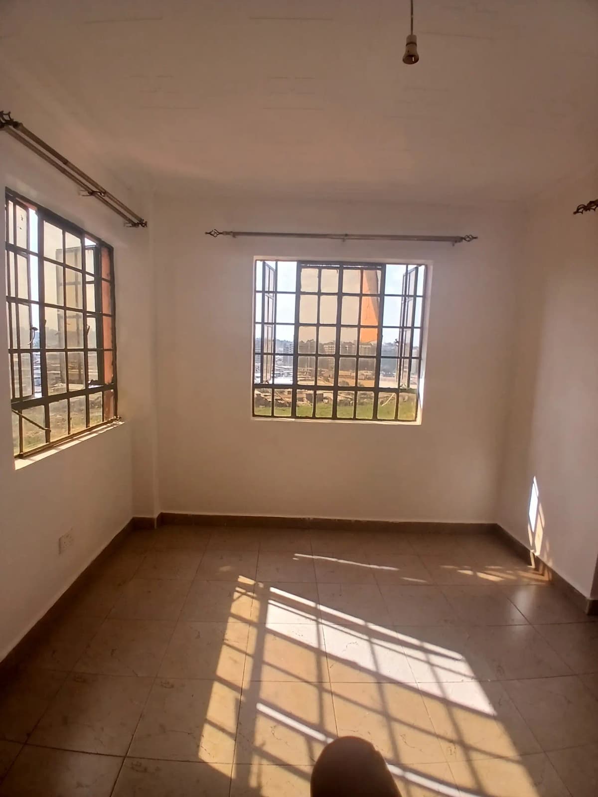 Bright bedroom with barred windows and terracotta tile floor