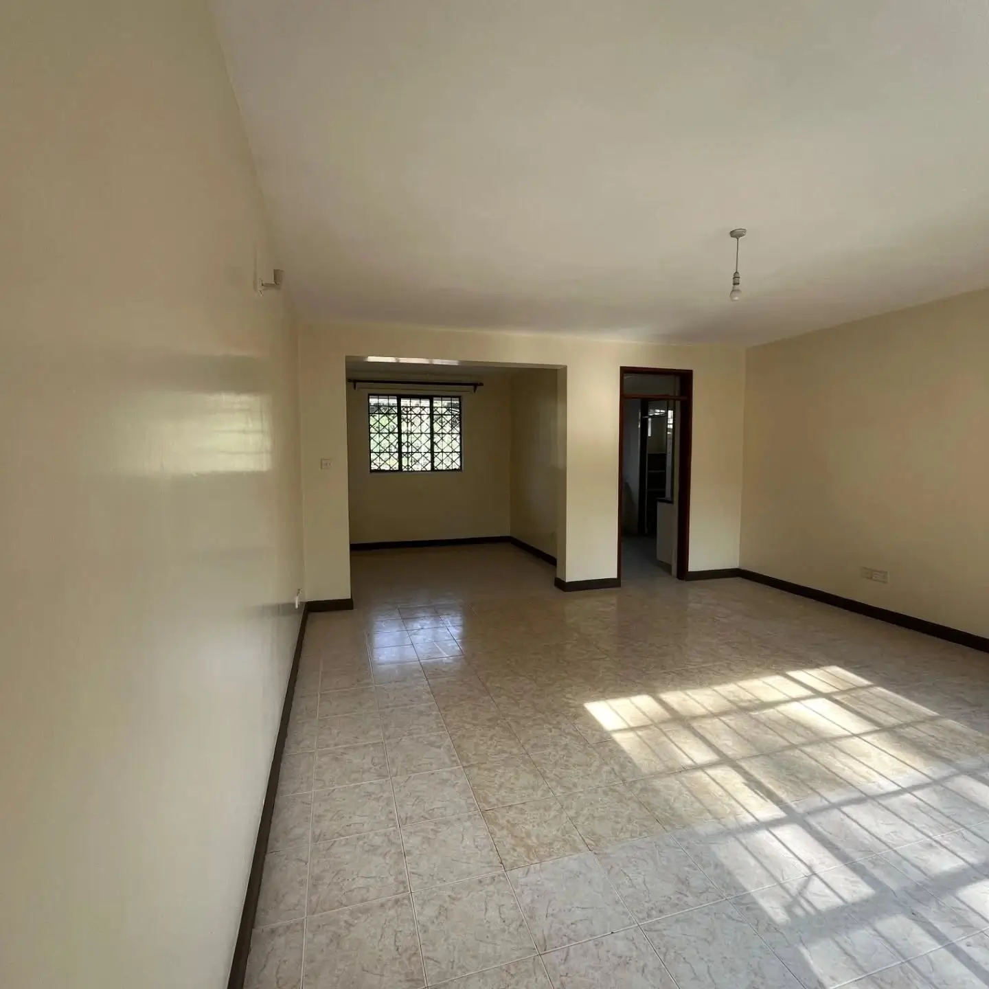 Spacious empty living room with tiled floor, natural light