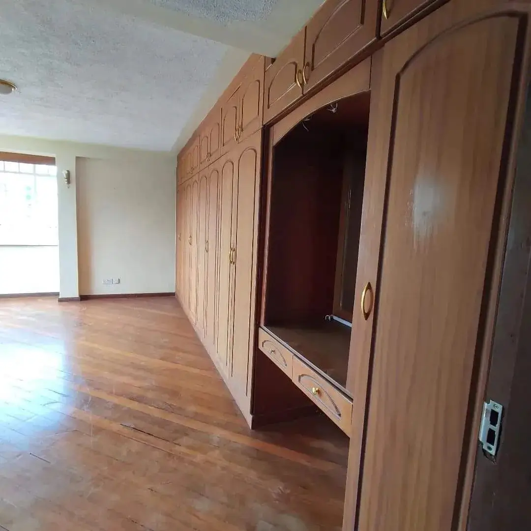 Bedroom with built-in wooden wardrobes and wood flooring