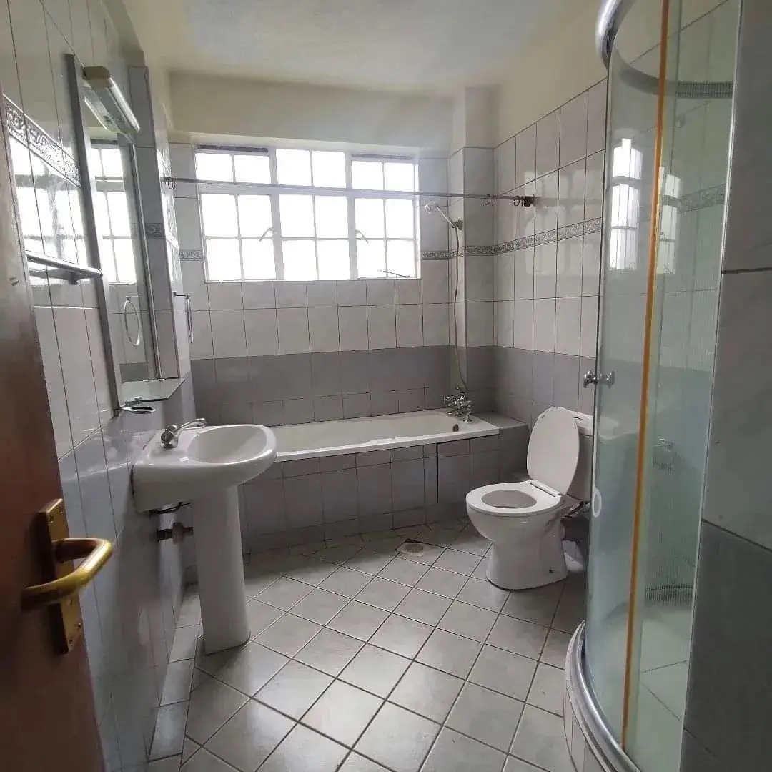 Spacious bathroom with bathtub, toilet, pedestal sink, shower