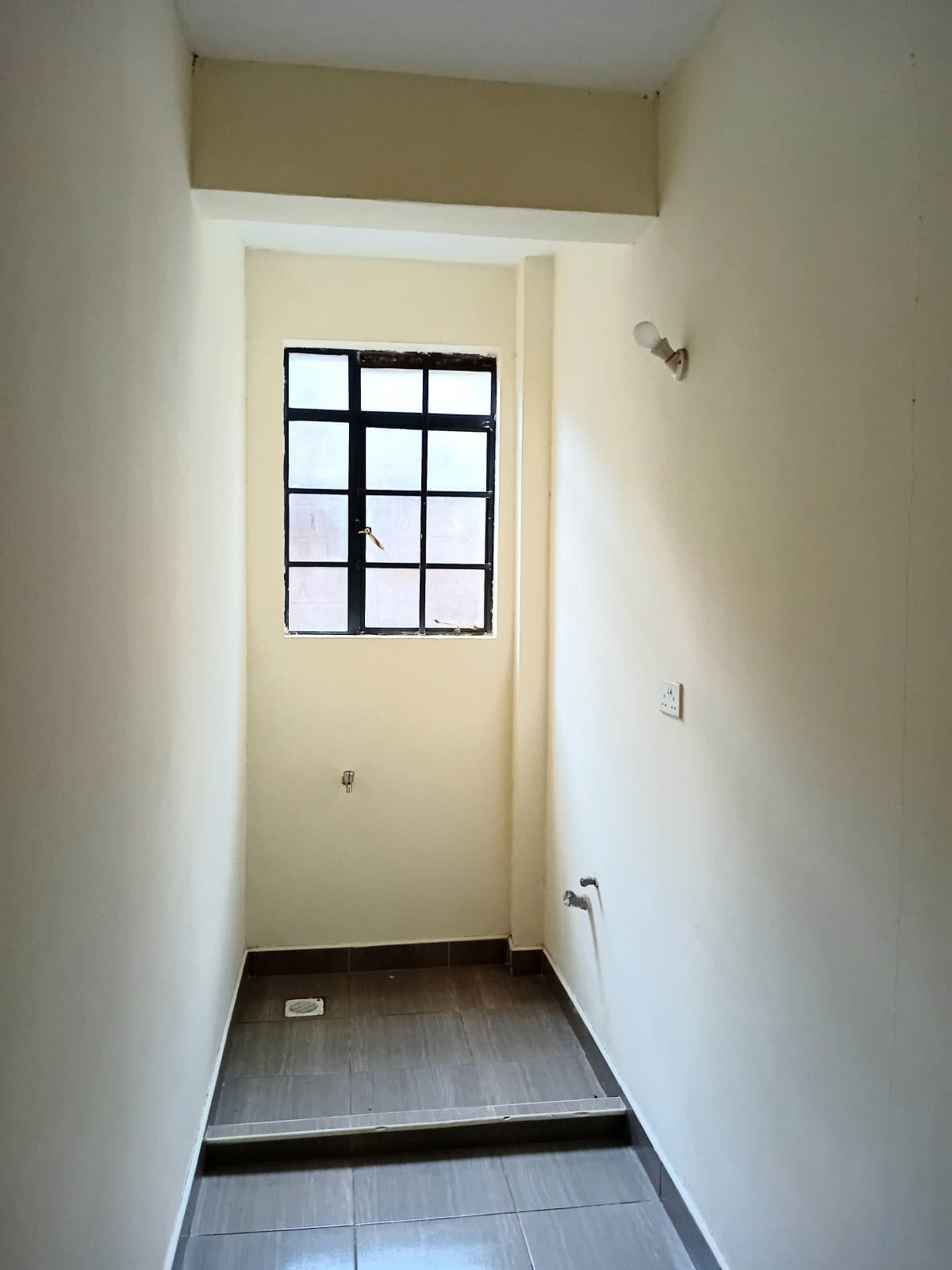Narrow hallway with grid window and tiled floor
