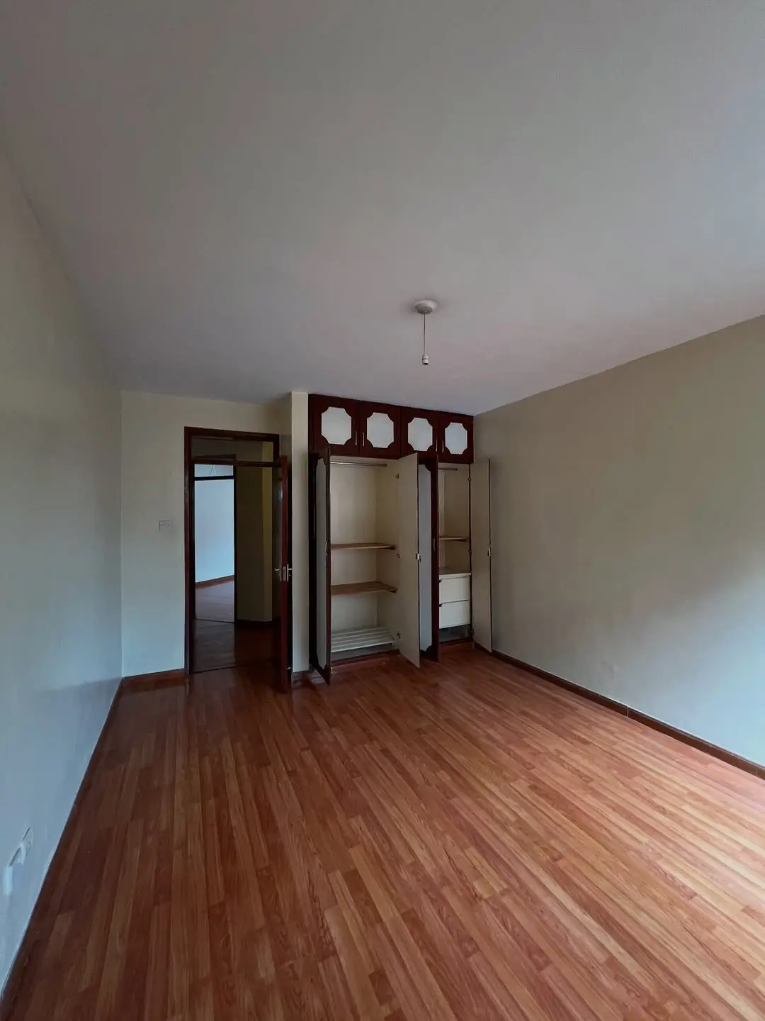 Spacious bedroom with wooden floors and built-in wardrobes
