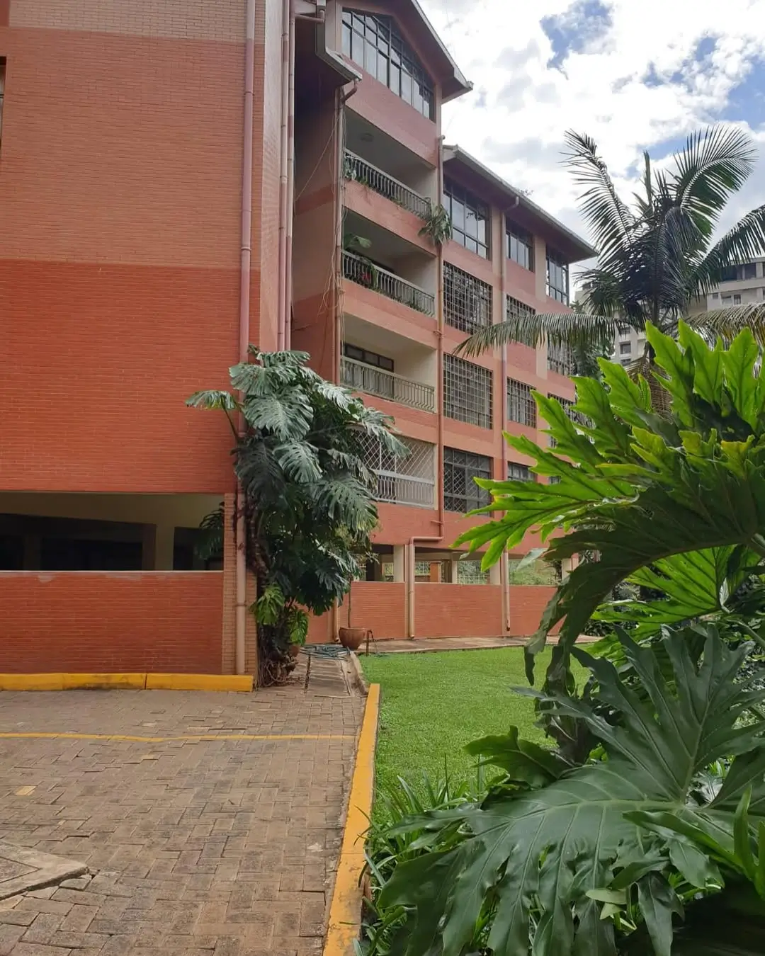 Multi-story residential building with manicured compound grounds