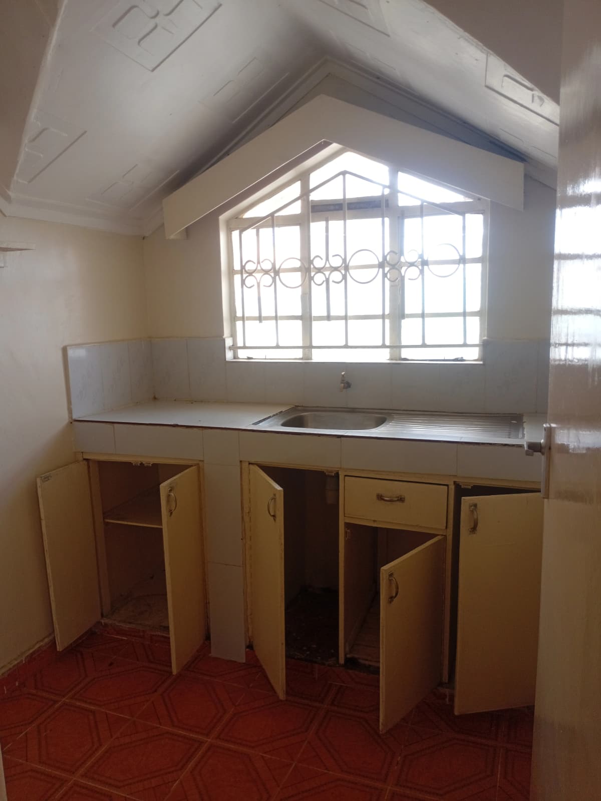 Compact kitchen with wooden cabinetry and sink counter