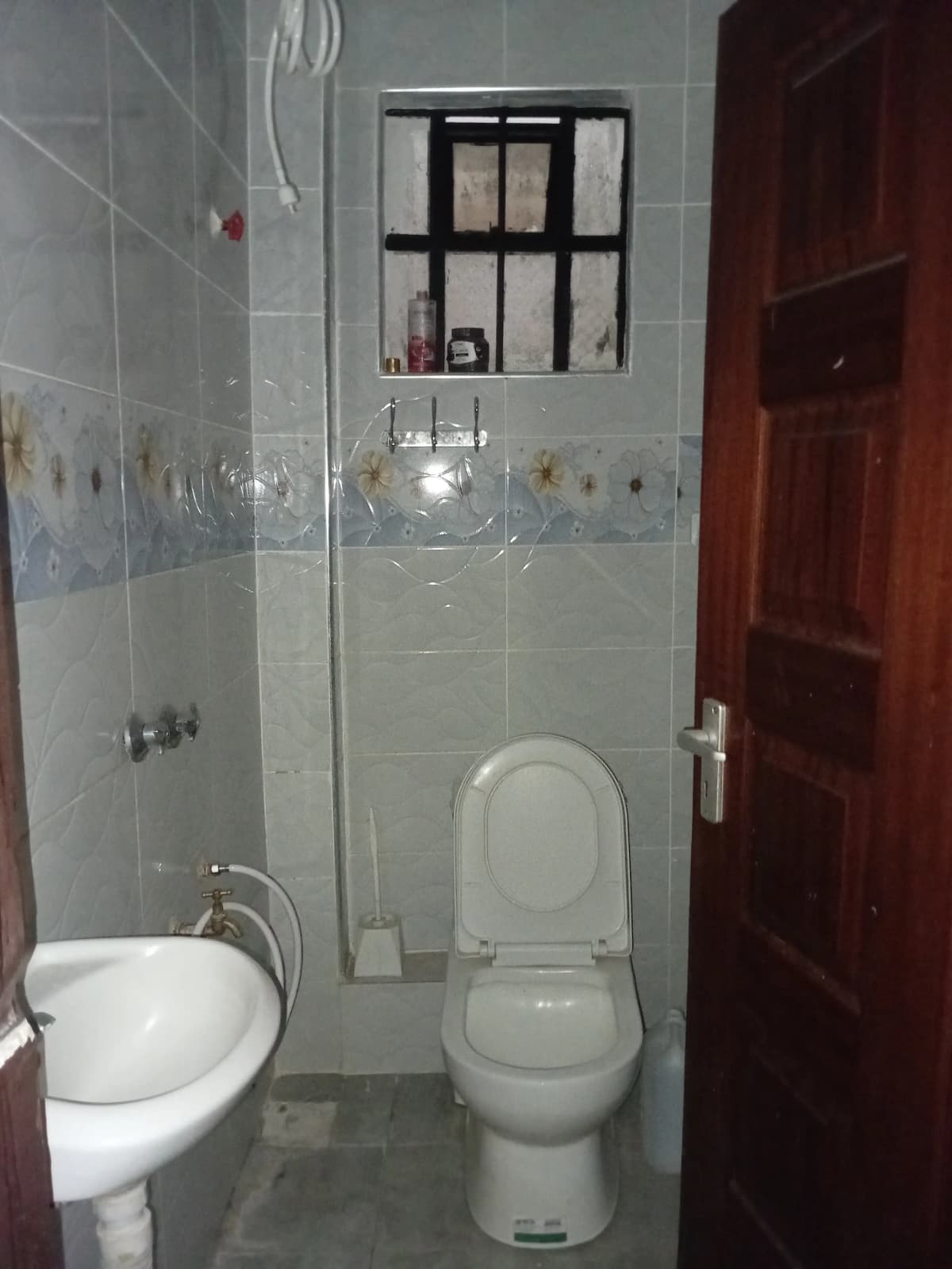 Compact bathroom with toilet, sink, and shower enclosure