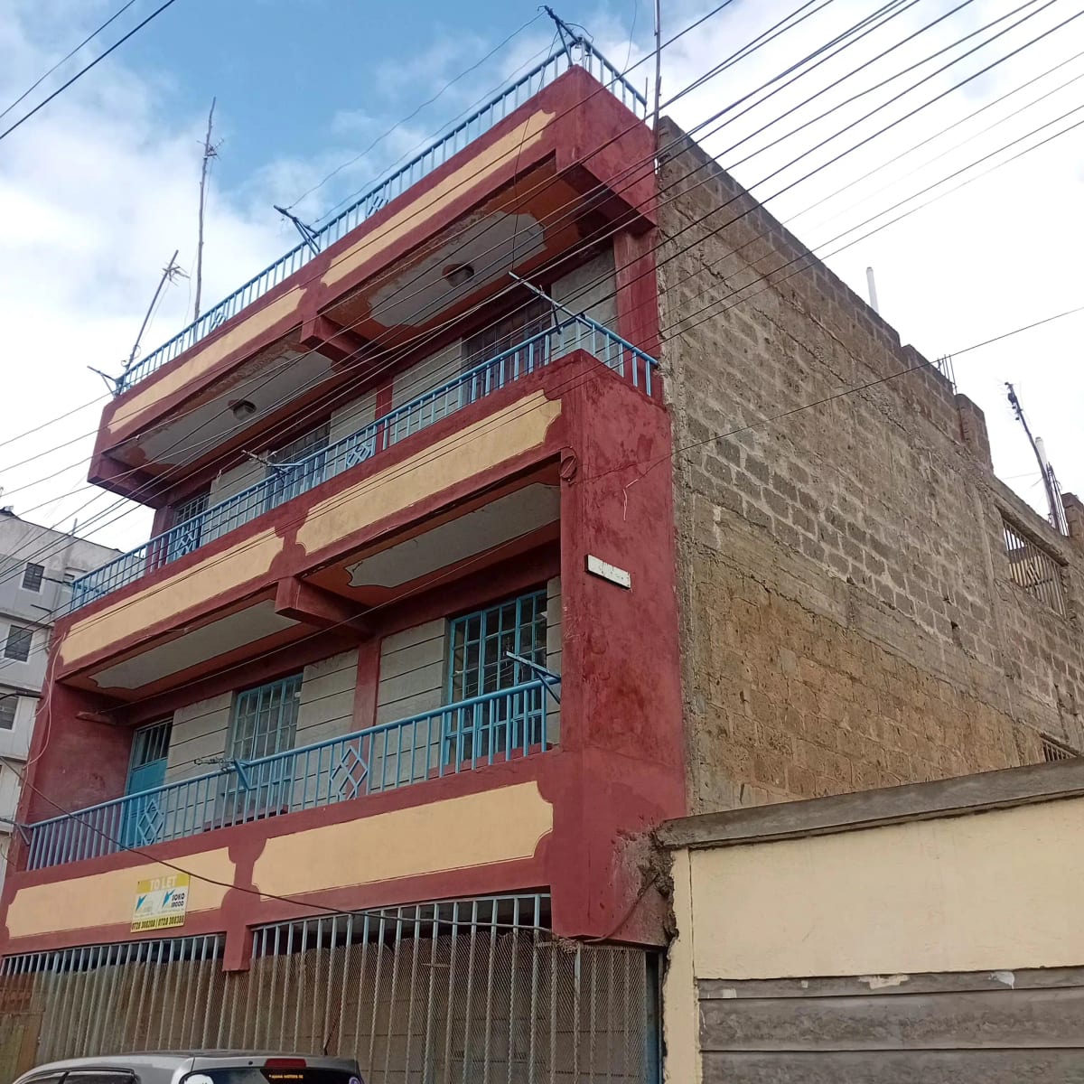 Multi-story residential building with red and cream facade