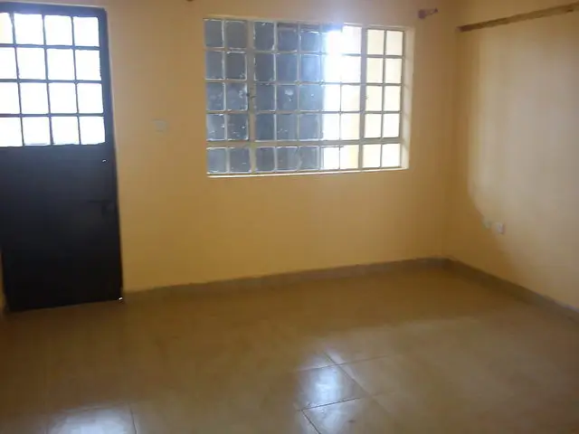 Empty living room with polished floor and barred windows