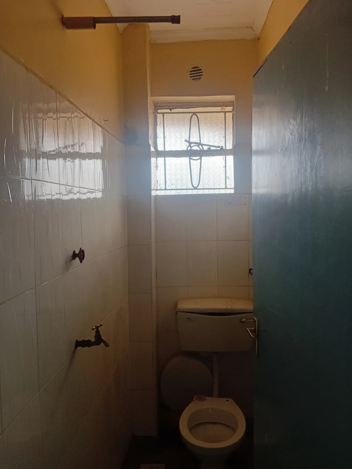 Compact bathroom with toilet, sink, and shower enclosure