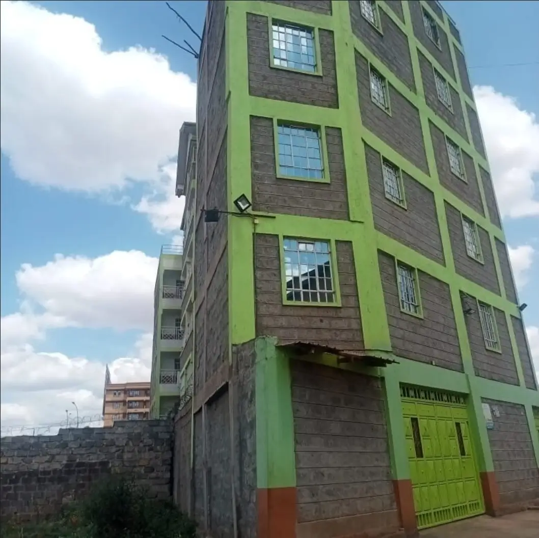 Modern apartment building facade with green trim and windows