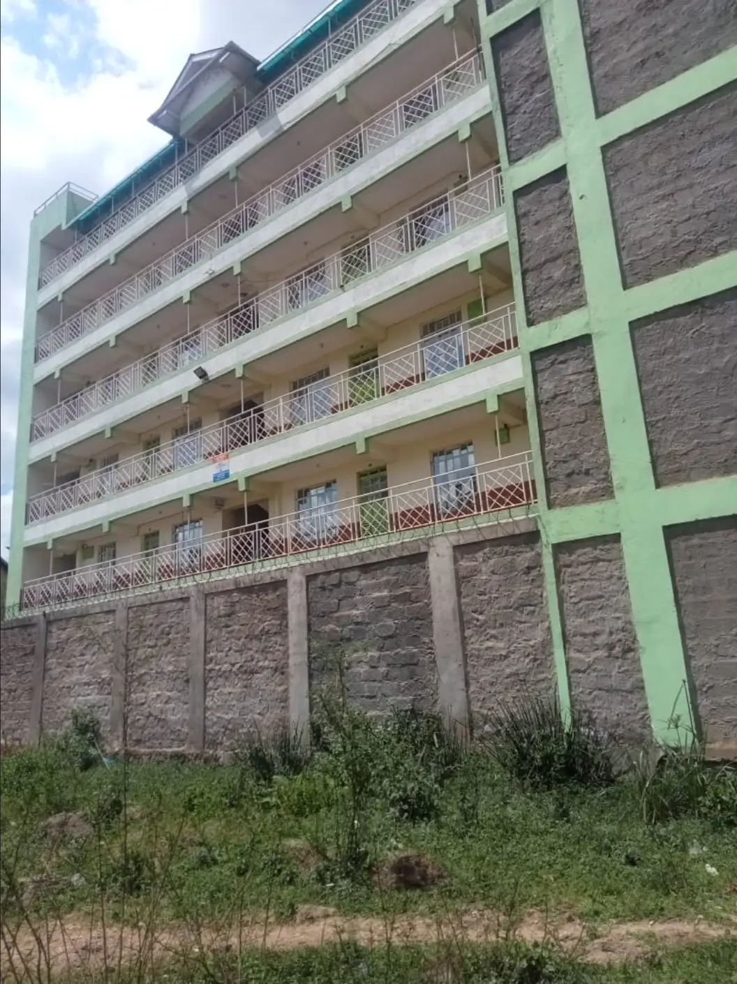 Multi-story residential building with green trim and balconies