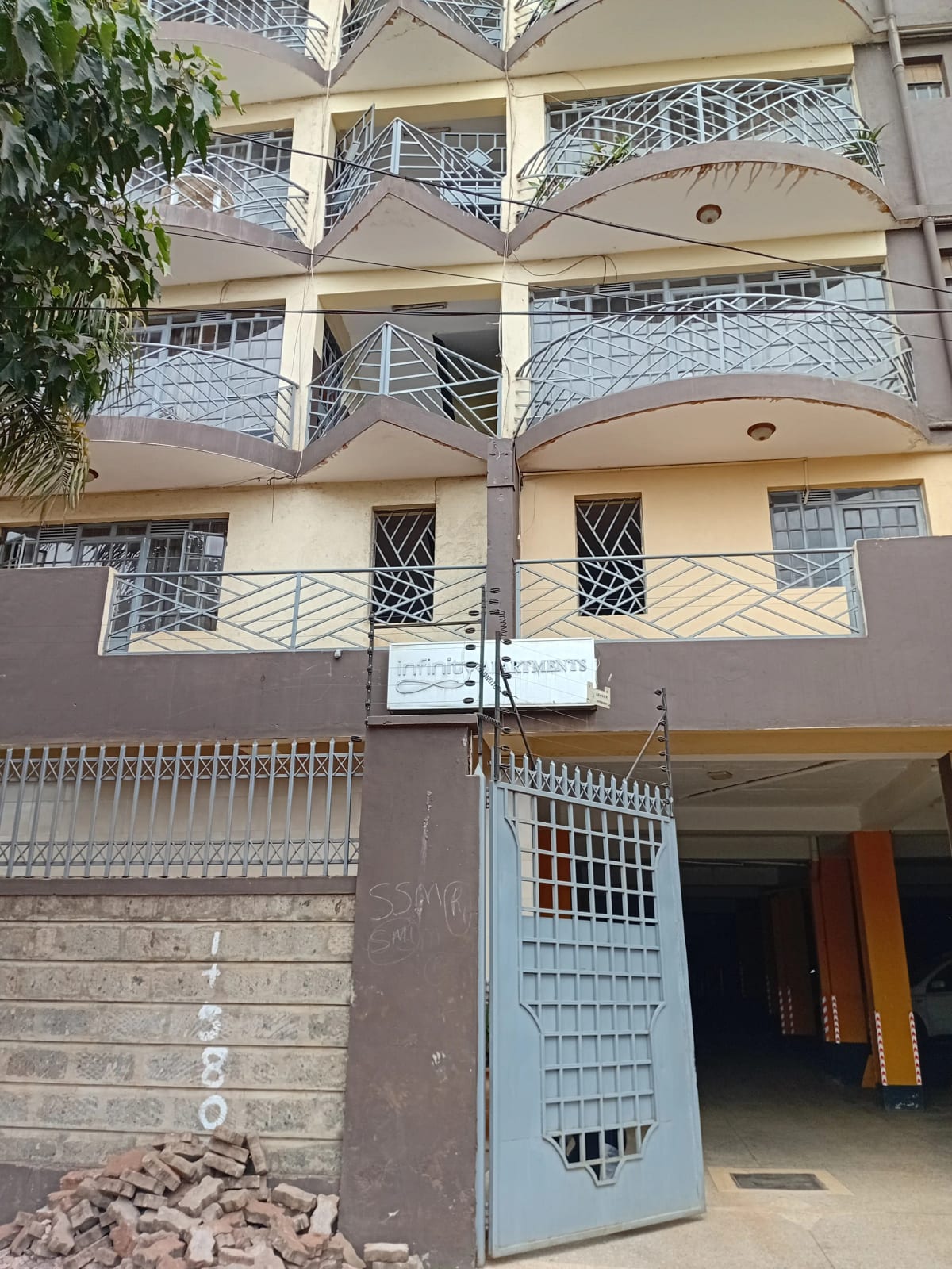 Multi-story residential building facade with balconies and gate entrance