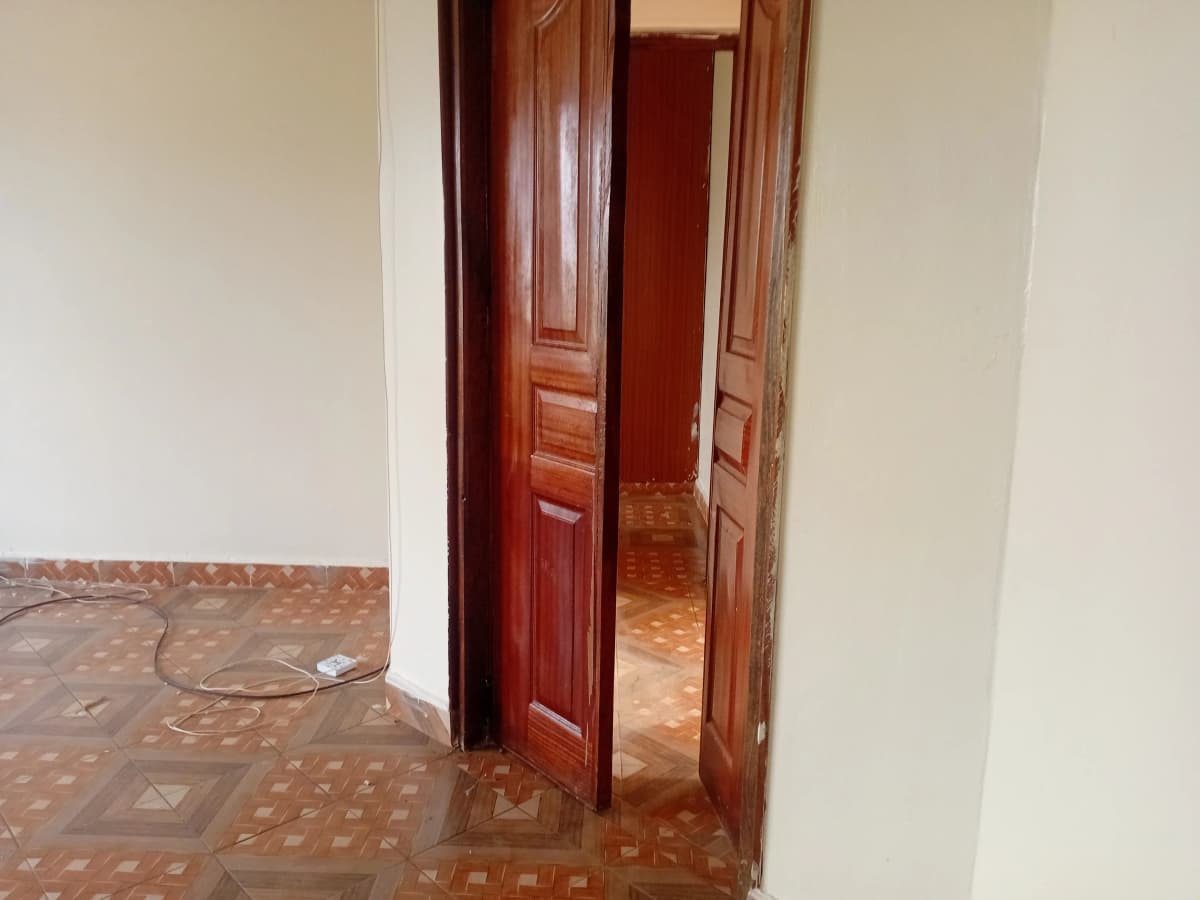 Corridor with wooden double doors and terracotta tile flooring