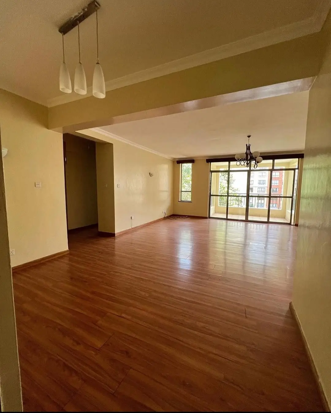 Spacious open-plan living area with wooden flooring and natural light