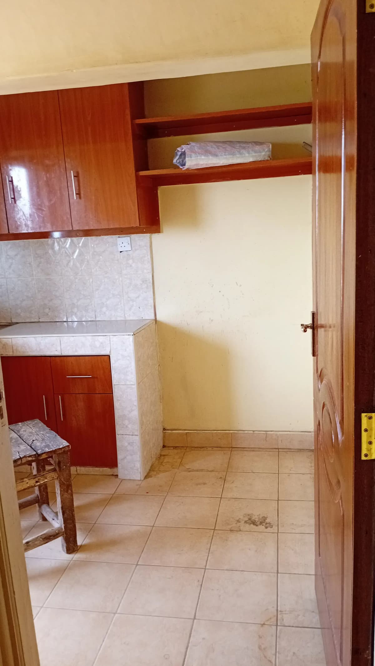 Compact kitchen with wooden cabinets and tiled flooring