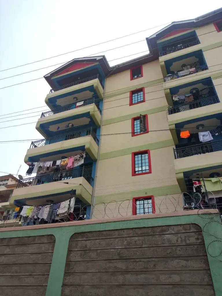 Multi-story residential building facade with green gate entrance