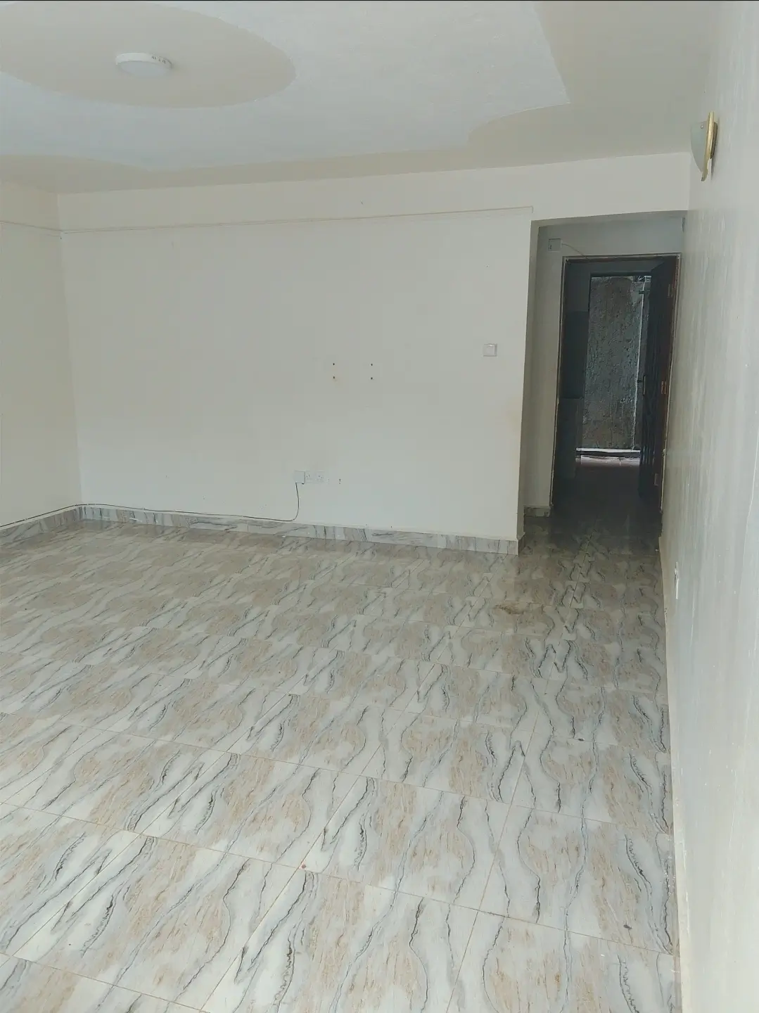Empty living room with wooden flooring and white walls
