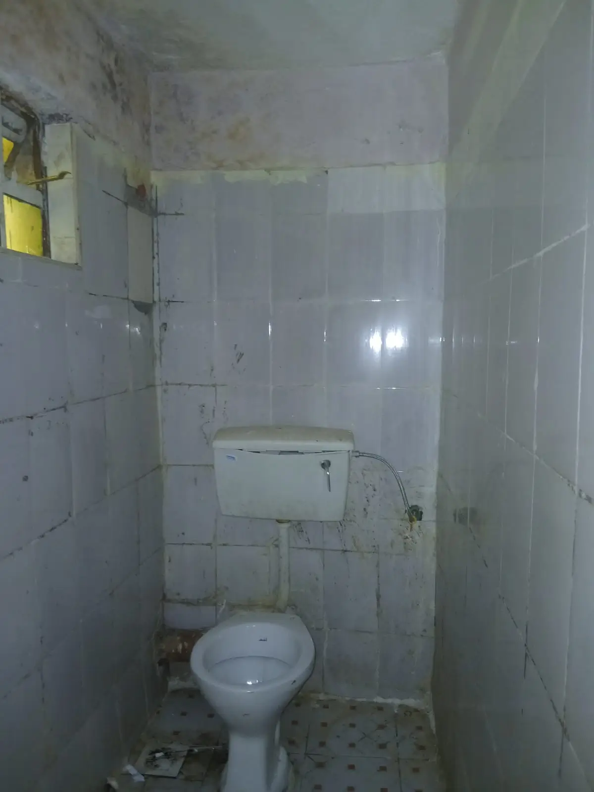 Simple bathroom with toilet, sink, and tiled walls