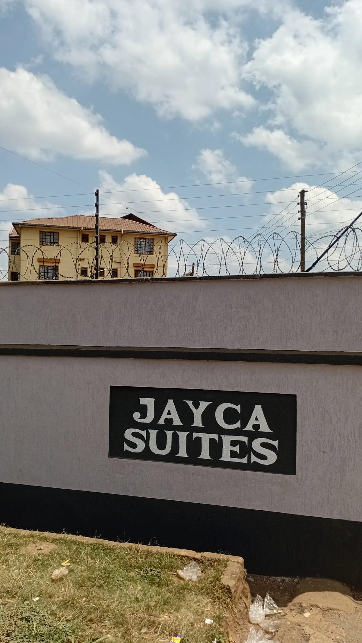 Jayca Suites building exterior with perimeter wall and signage