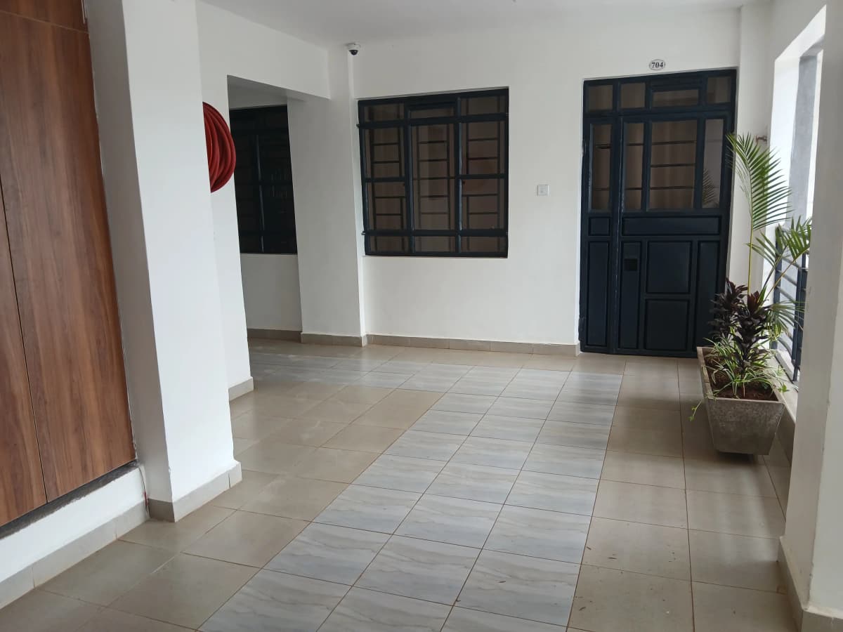 Bright corridor with tiled flooring and multiple dark wooden doors