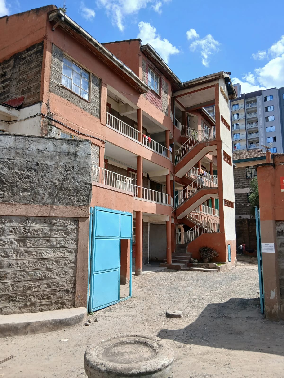 Multi-story residential building with terracotta facade and balconies