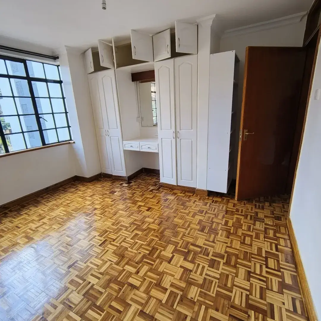 Spacious bedroom with built-in wardrobes and parquet flooring