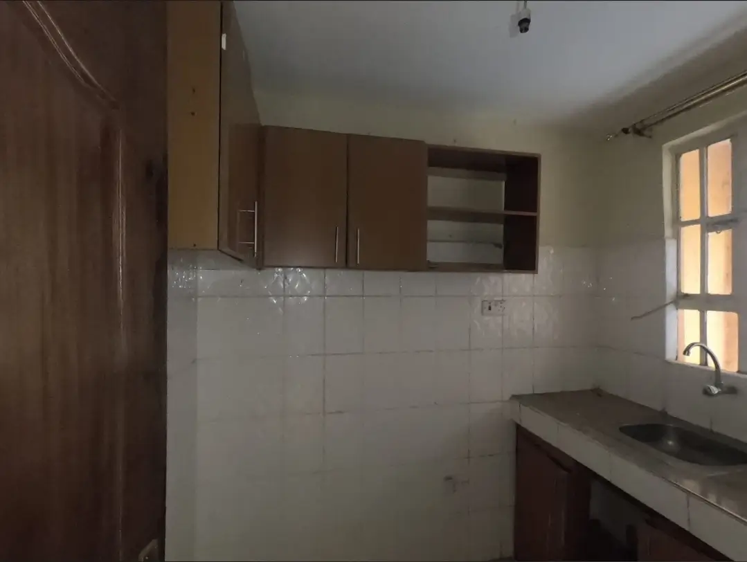 Compact kitchen with brown cabinetry and white tile backsplash