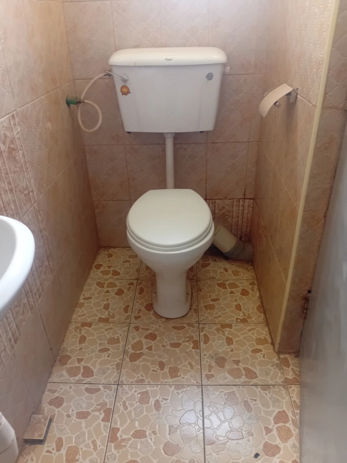 Basic toilet cubicle with ceramic tile flooring
