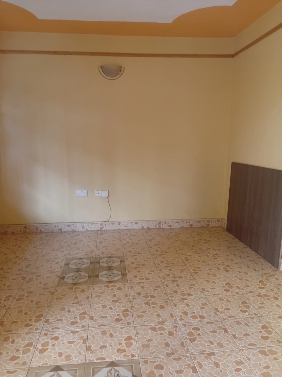Empty bedroom with terrazzo flooring and cream walls