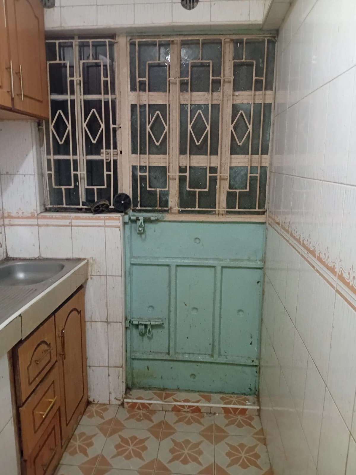 Compact kitchen with wooden cabinets and tiled flooring